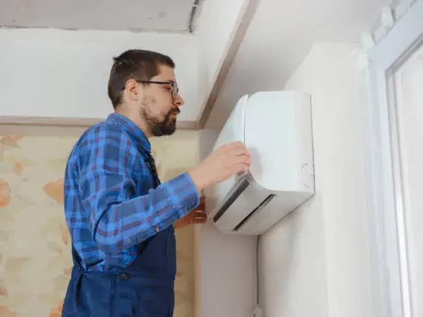 Electrician fixing a water leak in an air conditioning system.